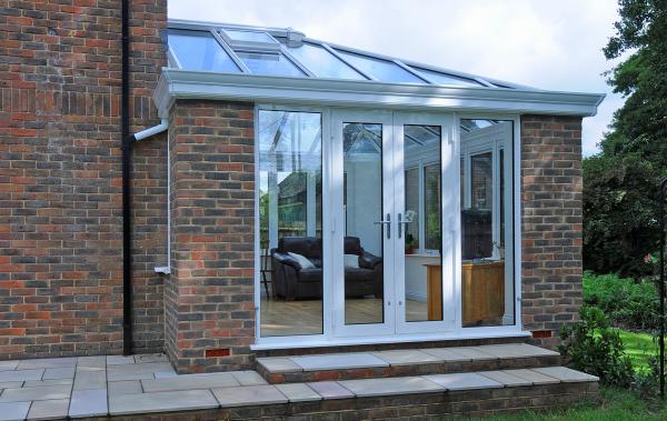 White aluminium garden room with French doors leading out to the garden